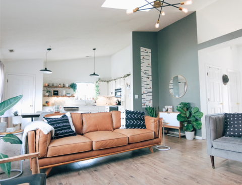 A bright living room with a leather sofa and a vaulted ceiling
