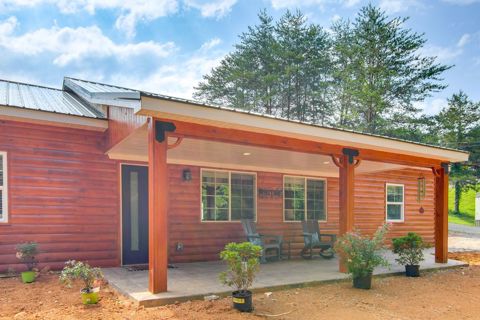 A log-sided cabin with a covered front porch and rocking chairs