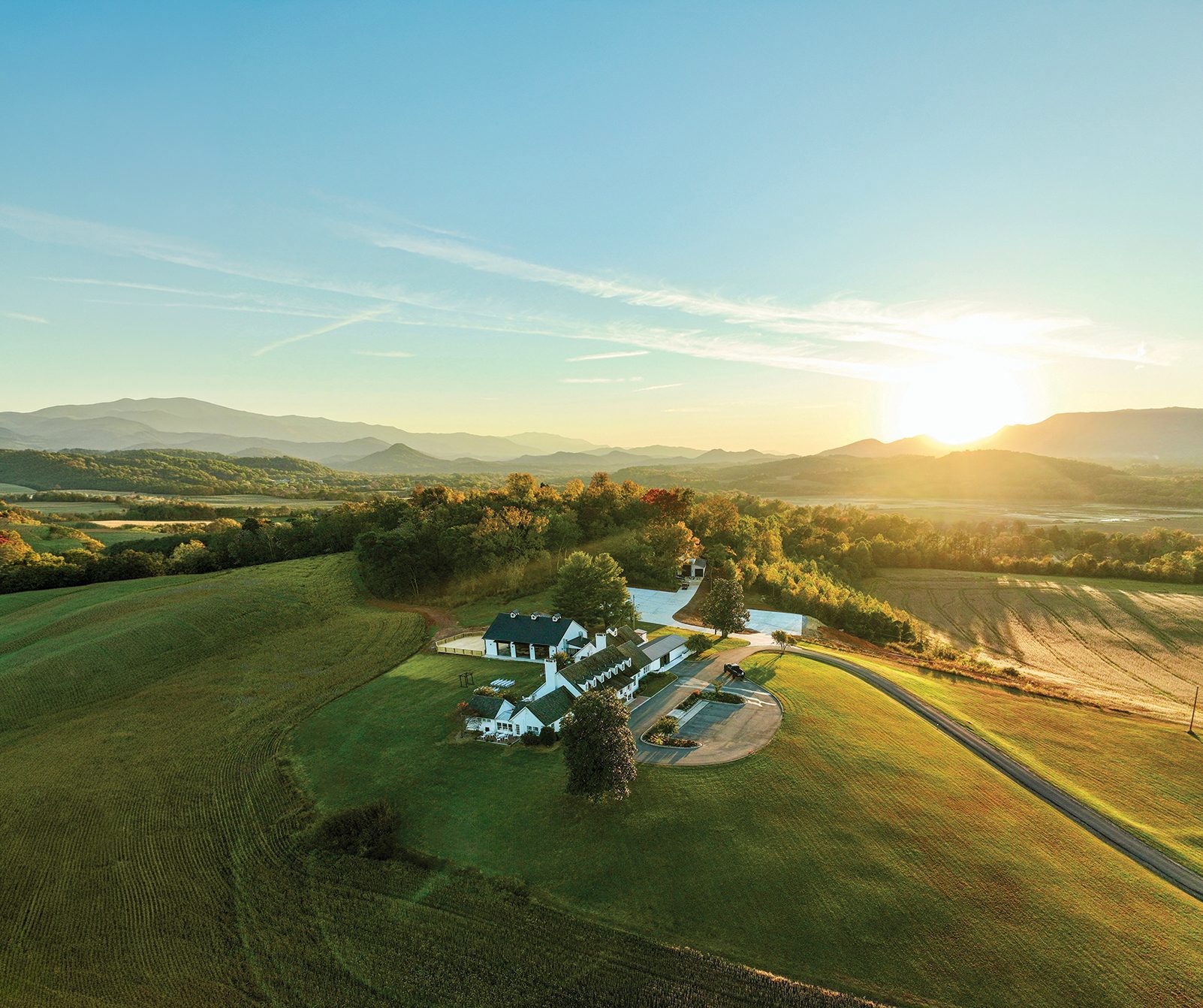 The estate from the air, sun going down behind the ridgelines