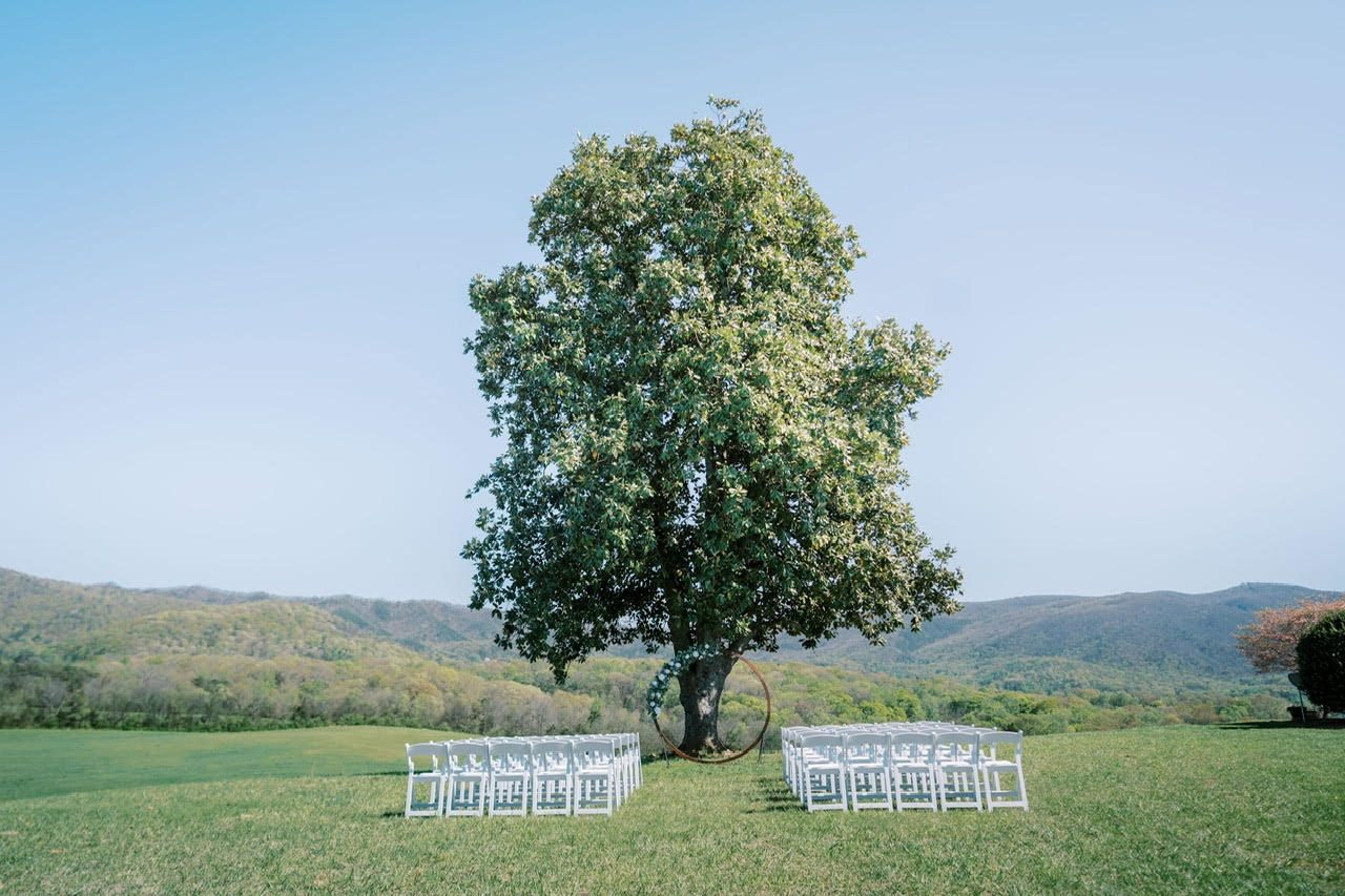 Ceremony chairs set out at the lone tree, ridgelines behind