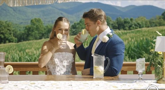 A couple raising a glass at a table above the valley