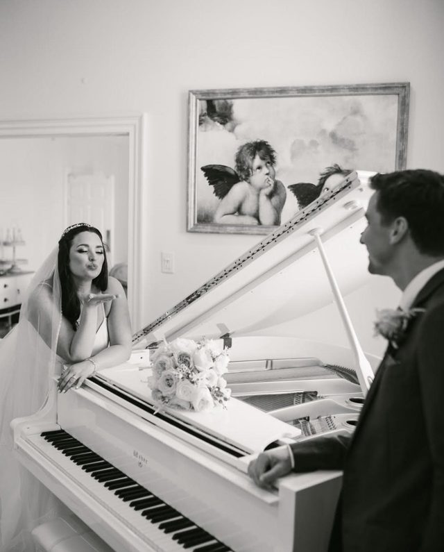 A couple at the white grand piano, in black and white