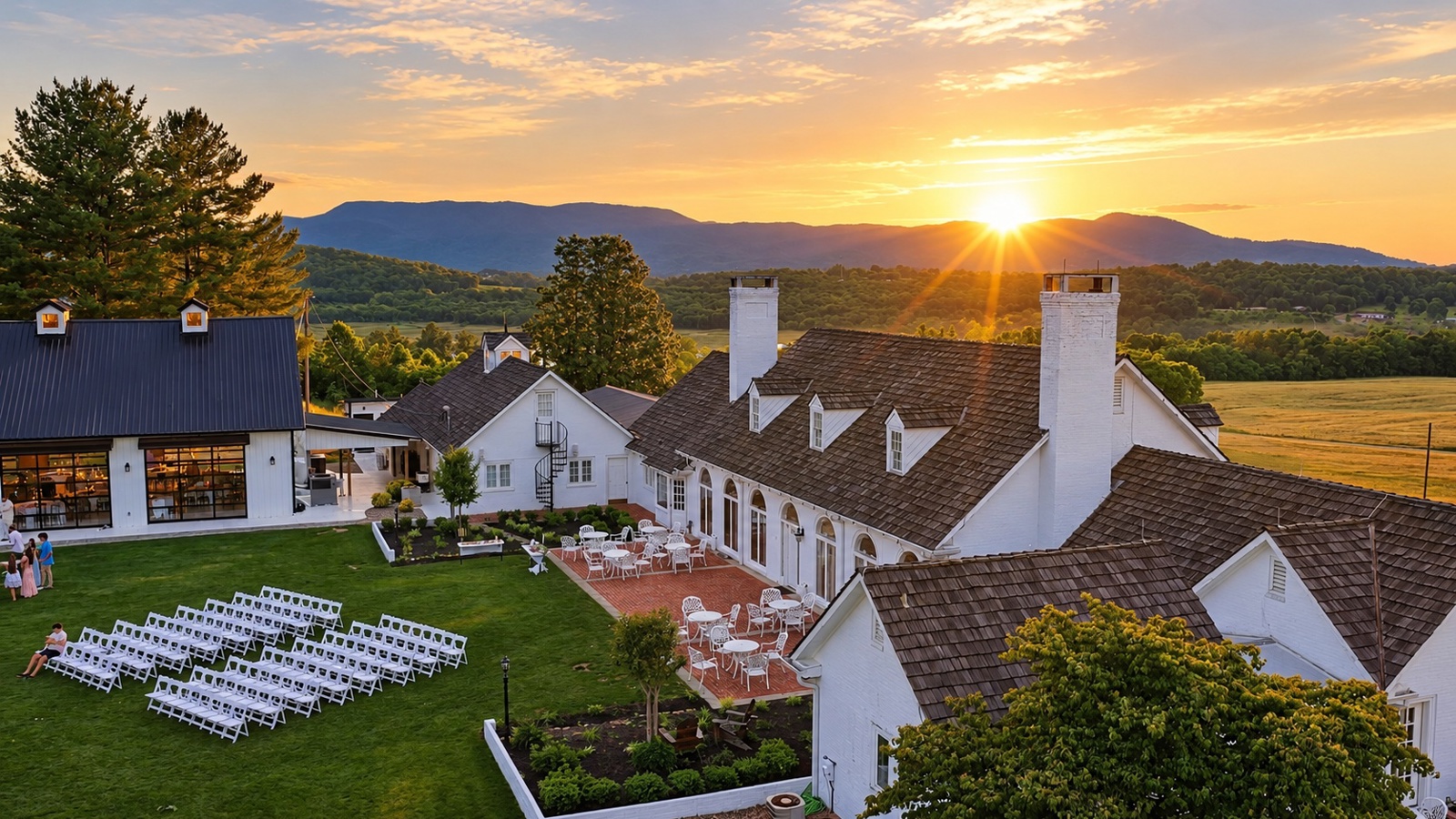 The Estate at Sweetwater Creek at sunset, ceremony chairs on the lawn and the Smoky Mountains beyond