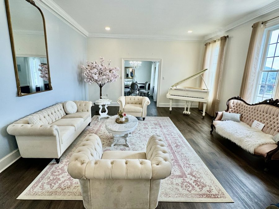 The parlour on the property, tufted sofas and the white piano