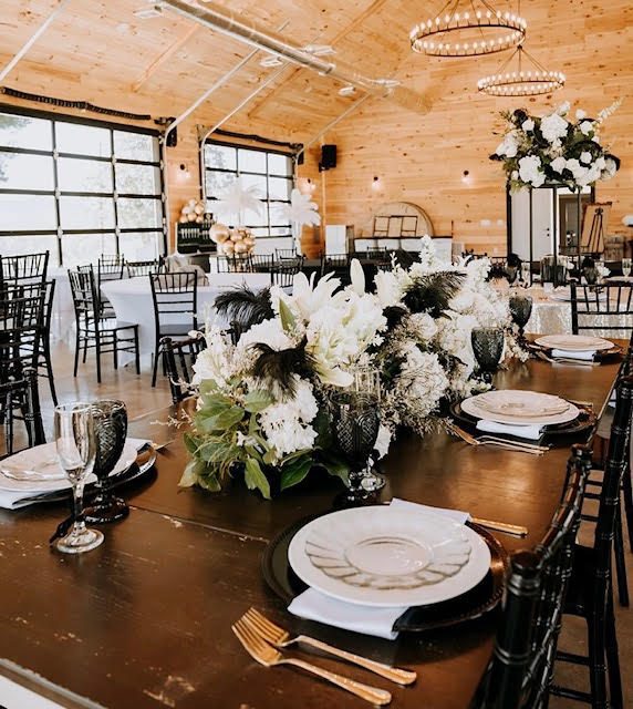 A place setting - gold cutlery, cut glassware and a black charger